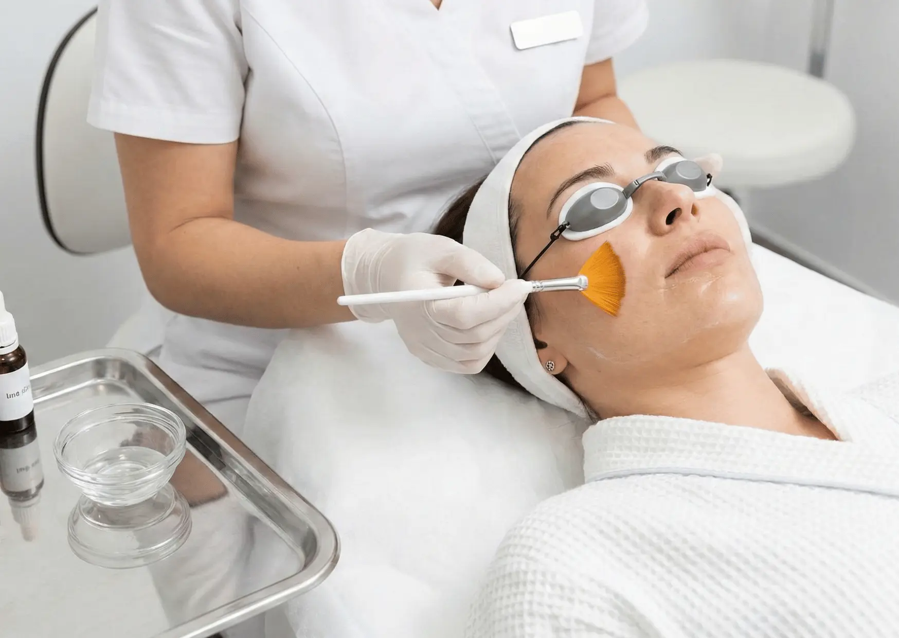 Aesthetician applying facial treatment serum to a patient at Arizona Medlaser