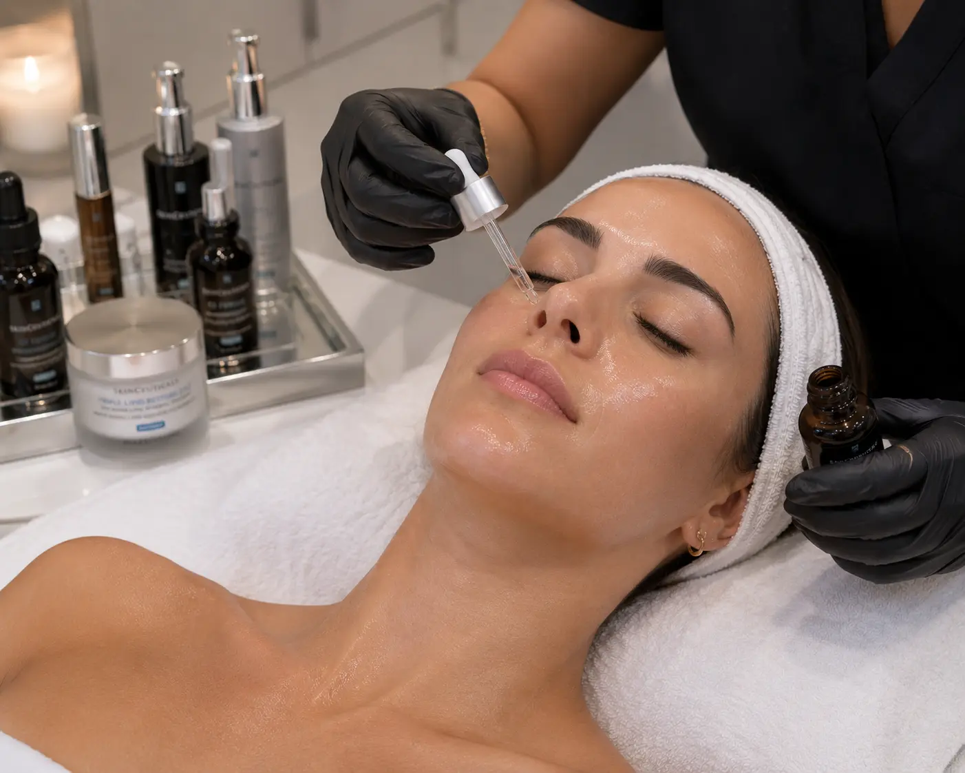 Aesthetician applying peptide serum to a client’s face during a skincare treatment